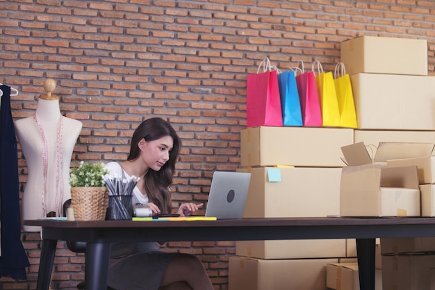 Una joven sastre con una computadora portátil está respondiendo correos electrónicos mujer de negocios éxito empresarial