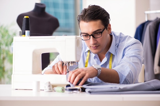 Joven sastre trabajando en ropa nueva