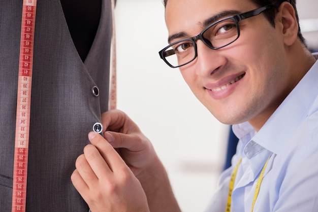 Joven sastre trabajando en ropa nueva