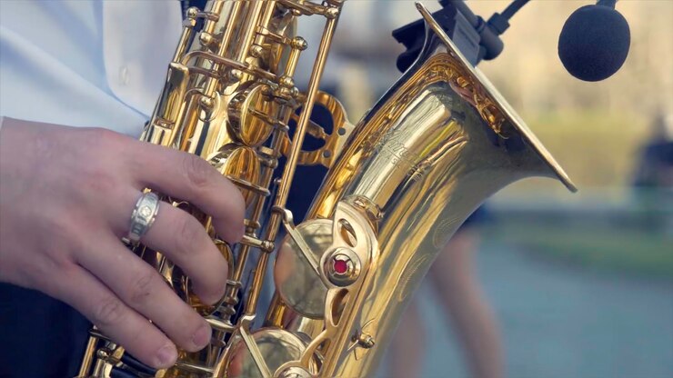 Foto joven con saxofón afuera cerca de la vieja pared pintada joven músico expresivo tocando el