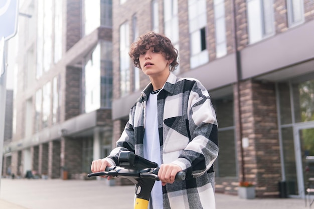 Joven en un scooter eléctrico paseos por la calle