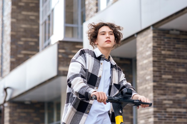 Un joven en un scooter eléctrico viaja por la calle