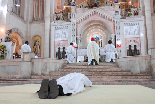 Foto un joven seminarista reza en una celebración religiosa antes de ser ordenado sacerdote