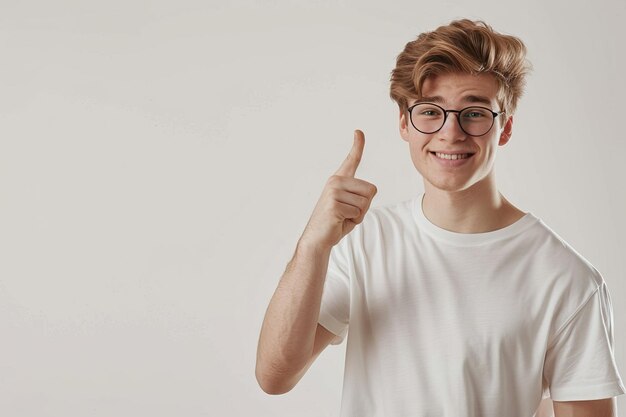 Joven señalando dirección y mirando a la cámara con sonrisa Fondo blanco Espacio de copia