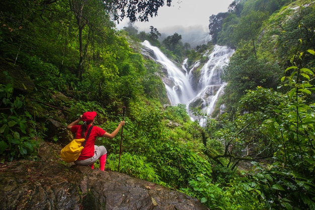 Foto joven, senderismo cerca de la cascada