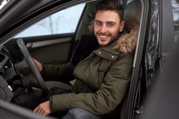 Joven sentado al volante de su coche