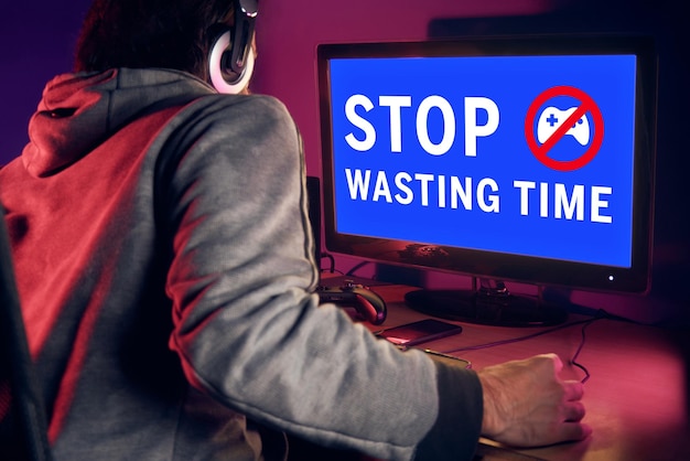 Joven sentado frente a una pantalla de PC que muestra una pantalla azul con un mensaje de advertencia Deja de perder el tiempo