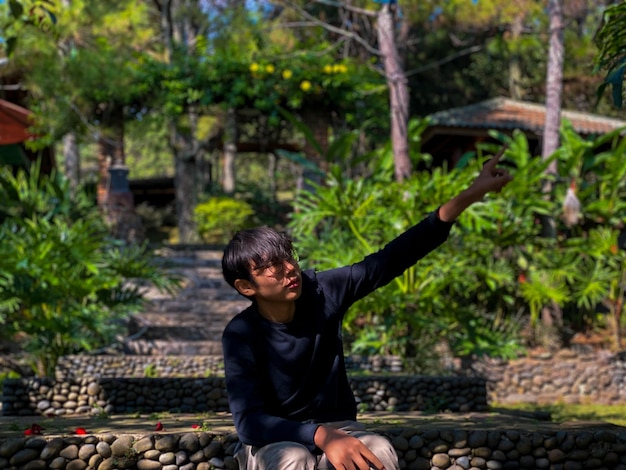 Foto un joven sentado en el parque.