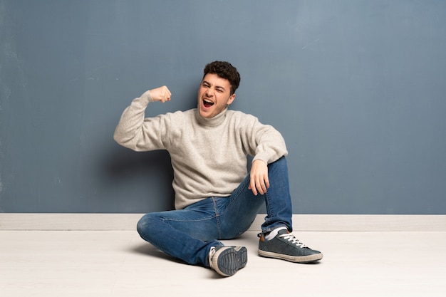 Joven sentado en el suelo haciendo un gesto fuerte