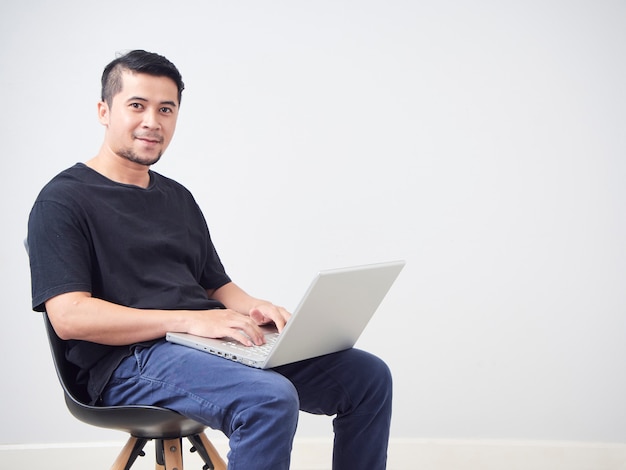 Joven sentado trabajo con laptop