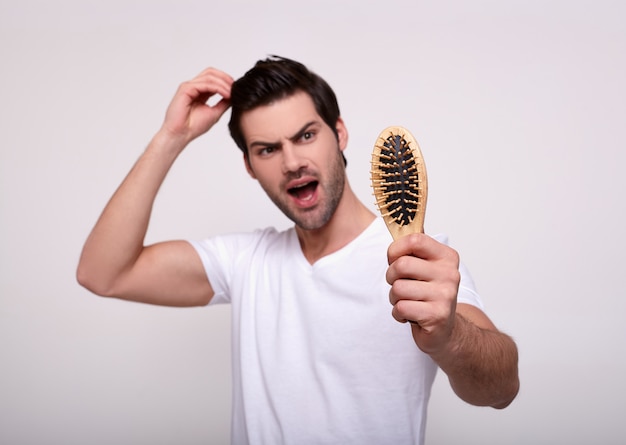 Joven serio problema de pérdida de cabello para el cuidado de la salud médica y el concepto de producto de champú.