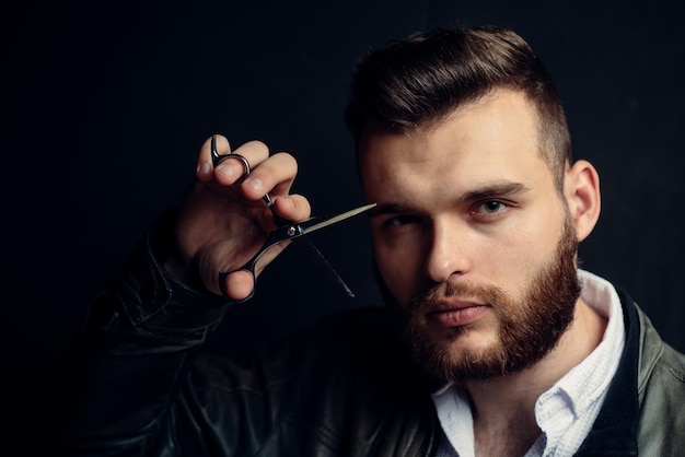 Joven sexy retrato de hombre con tijeras de peluquero para peluquería moderna peluquería afeitado handso ...