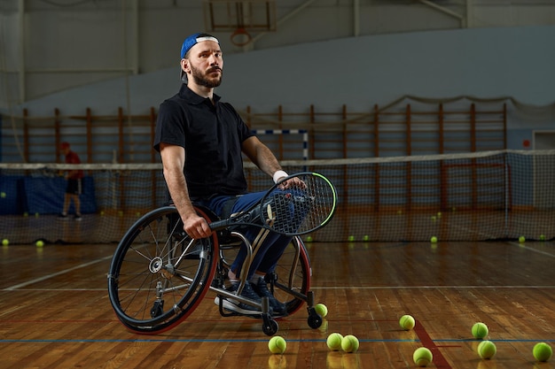 Joven en silla de ruedas jugando al tenis en la cancha.