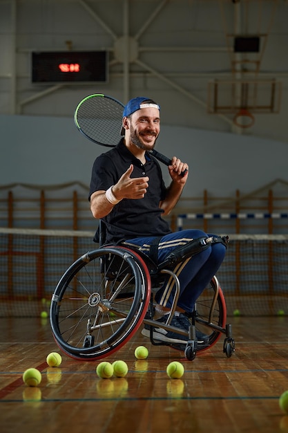 Joven en silla de ruedas jugando al tenis en la cancha