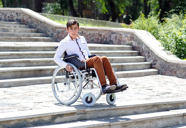 Un joven en silla de ruedas que no puede bajar las escaleras.