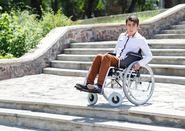 Un joven en silla de ruedas que no puede bajar las escaleras.