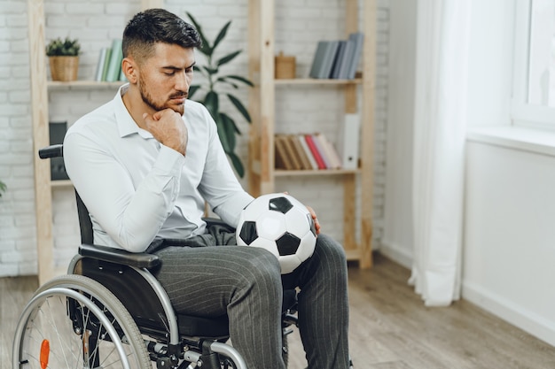 Joven en silla de ruedas sosteniendo una pelota de fútbol