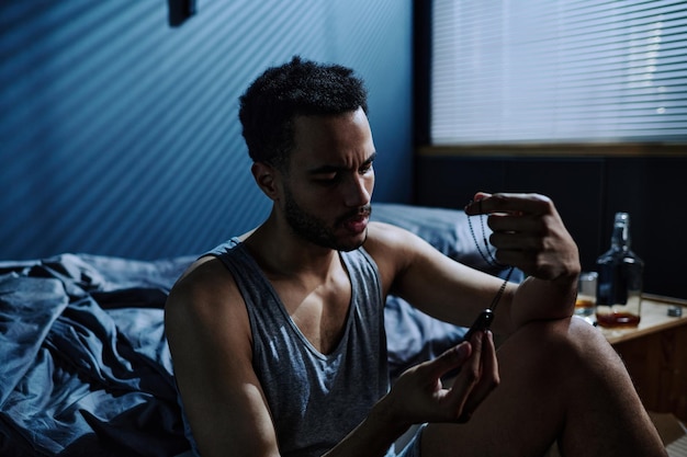 Joven con síndrome postraumático mirando medallón metálico