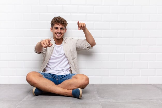 Joven sintiéndose feliz y seguro, señalando