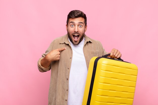 Joven sintiéndose feliz, sorprendido y orgulloso, apuntando a sí mismo