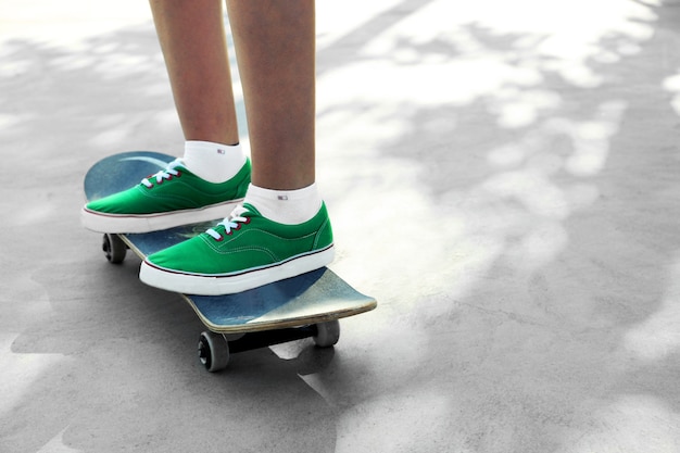 Joven skater en gumshoes de pie en skate