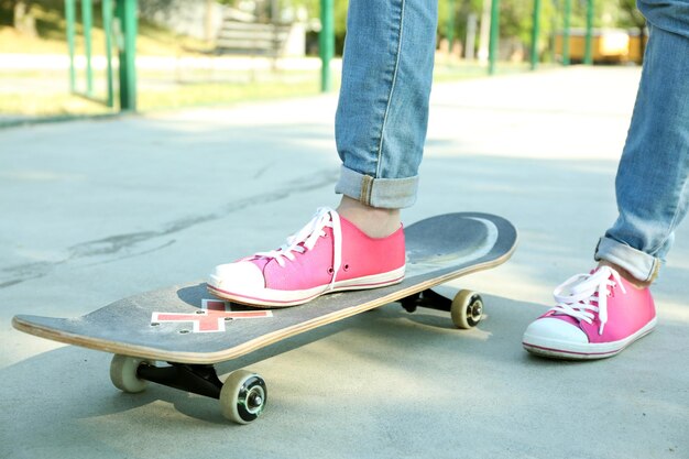 Joven skater en gumshoes de pie en skate