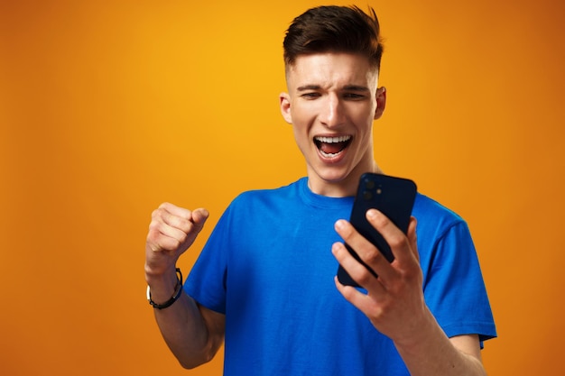 Joven con smartphone contra fondo amarillo