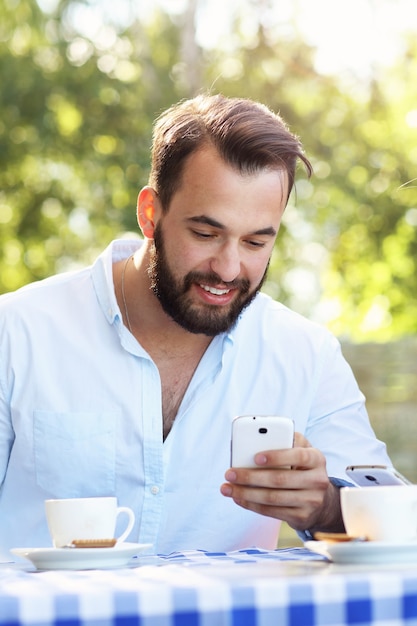 joven, con, smartphone, en, restaurante