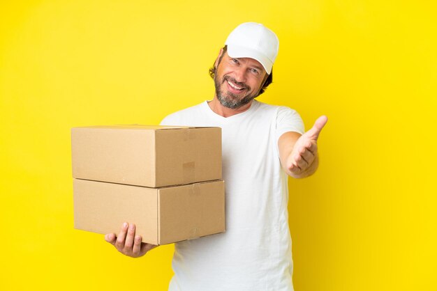 Joven sobre fondo azul con caja de regalo en las manos