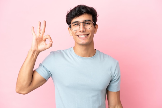 Joven sobre fondo azul sosteniendo una casita