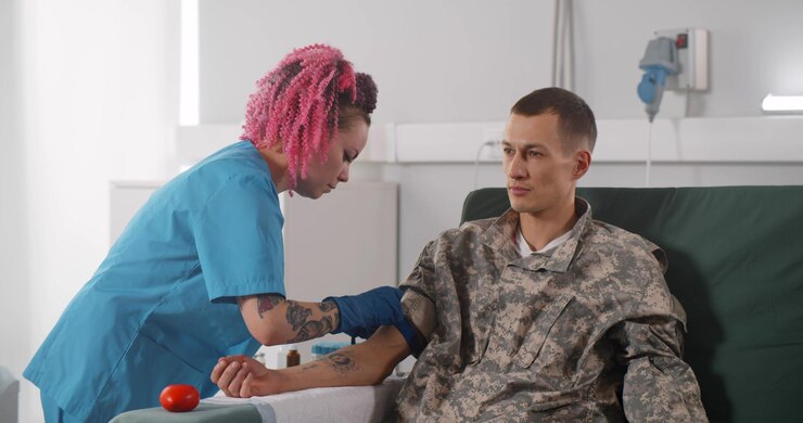 Joven soldado donando sangre en el centro de hemotransfusión