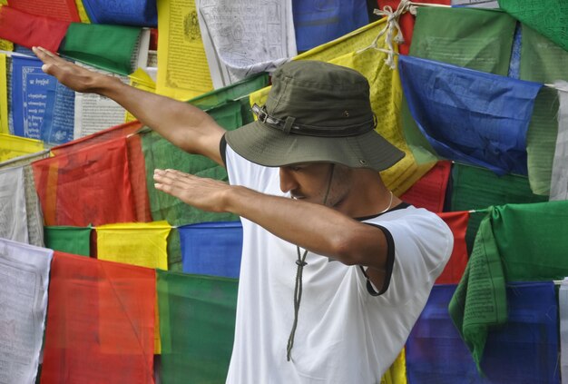 Foto joven con sombrero de pie contra la bandera de oración