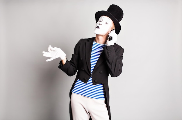 Joven con sombrero de pie contra un fondo blanco