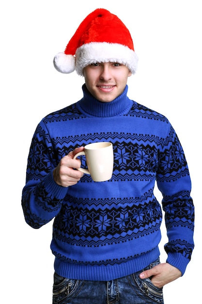 Joven con sombrero rojo de Papá Noel con una taza de té caliente