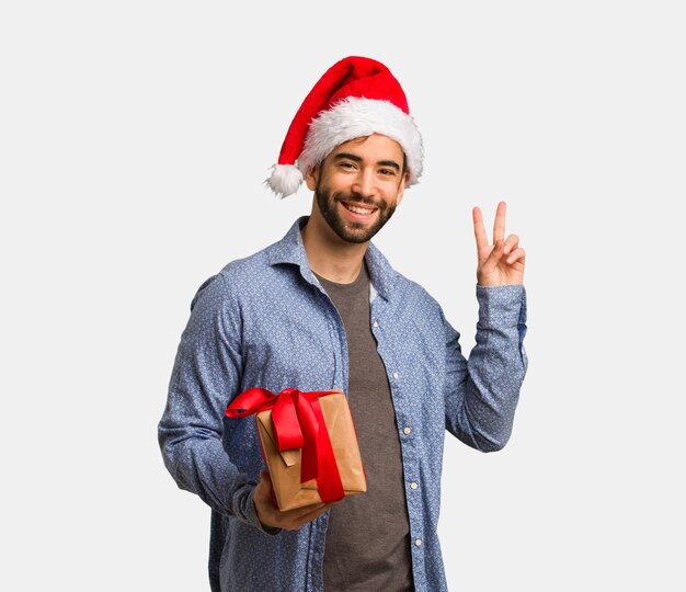 Joven con sombrero de santa haciendo un gesto de victoria