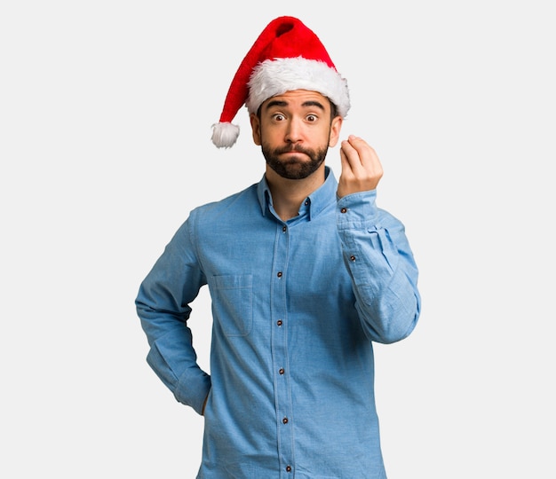 Joven con sombrero de santa haciendo un típico gesto italiano