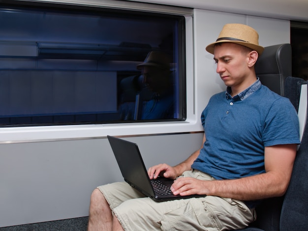 Joven con sombrero trabajando en una silla de tren