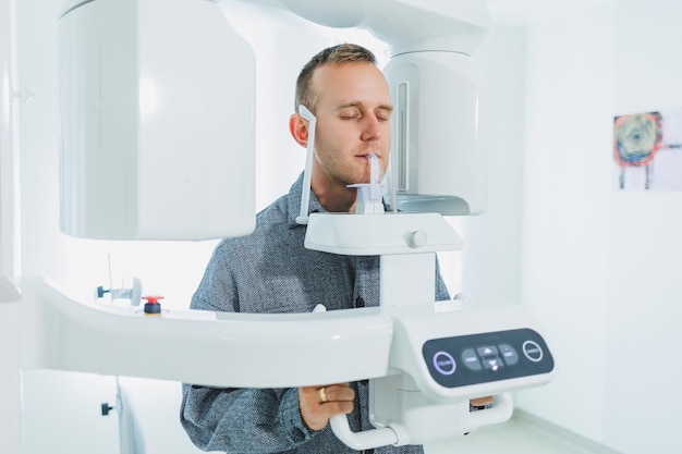 Un joven se sometió a una tomografía computarizada de la mandíbula una imagen circular de la mandíbula en la odontología moderna Escáner panorámico de radiología