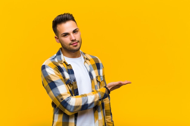 Joven sonriendo alegremente, sintiéndose feliz y mostrando algo