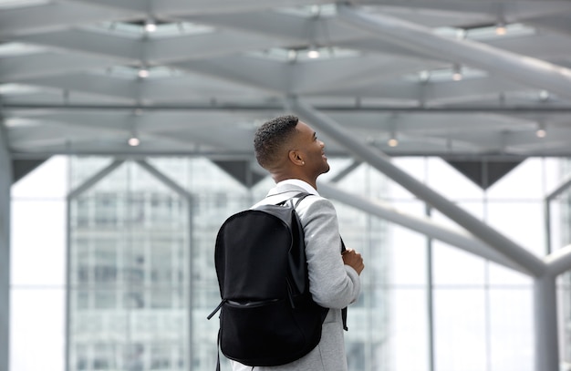 Joven sonriendo con bolsa en el aeropuerto