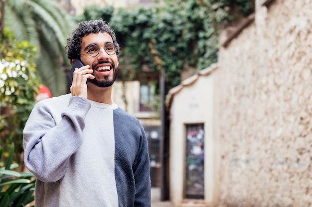 Joven sonriendo feliz hablando por teléfono