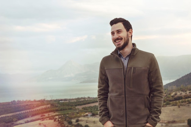 Foto joven sonriendo mientras está de pie contra el cielo