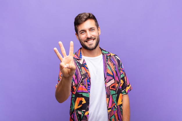 Joven sonriendo y mirando amigablemente, mostrando el número tres o tercero con la mano hacia adelante, contando hacia atrás