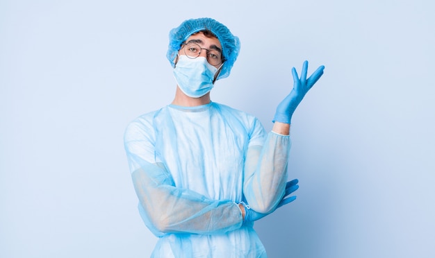 Joven sonriendo con orgullo y confianza, sintiéndose feliz y satisfecho y mostrando un concepto en el espacio de la copia. concepto de coronavirus