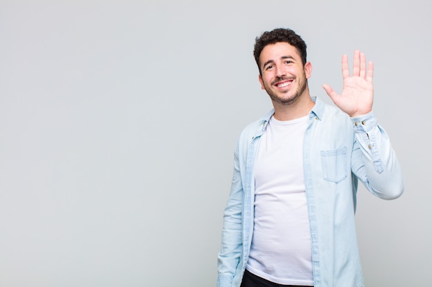 Foto joven sonriendo y saludando