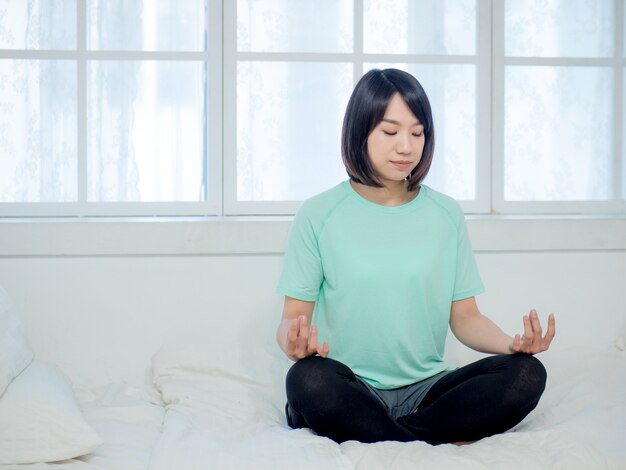 Joven sonriente atractiva mujer yogui practicando yoga