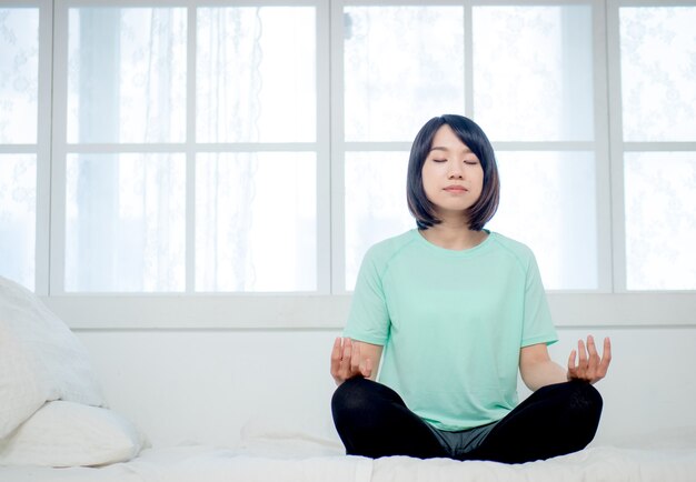 Joven sonriente atractiva mujer yogui practicando yoga