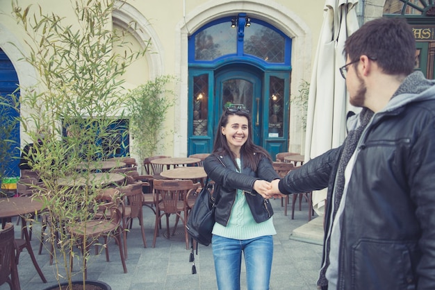 Una joven sonriente atrae a un hombre al restaurante.