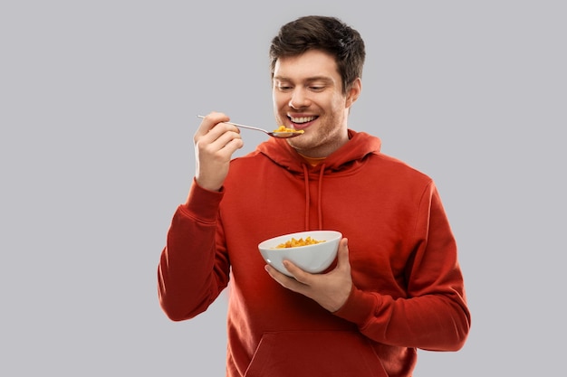 joven sonriente con capucha roja comiendo cereales