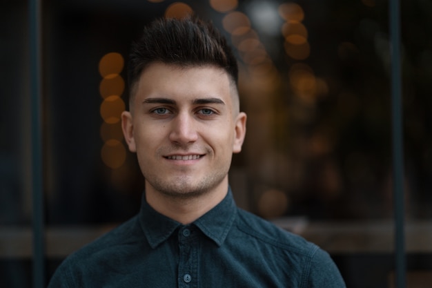 Foto joven sonriente cerca retrato con luces de fondo